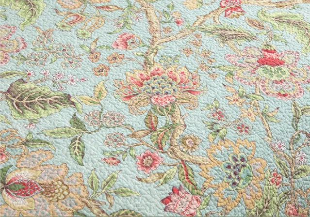 Blue American floral and bird pattern quilted cotton bedspread set on a double bed