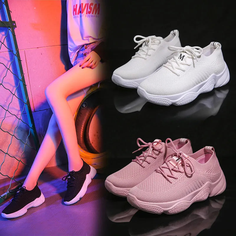 Women's low-top white sport shoes with thick rubber sole and woven upper, showing front strap closure.