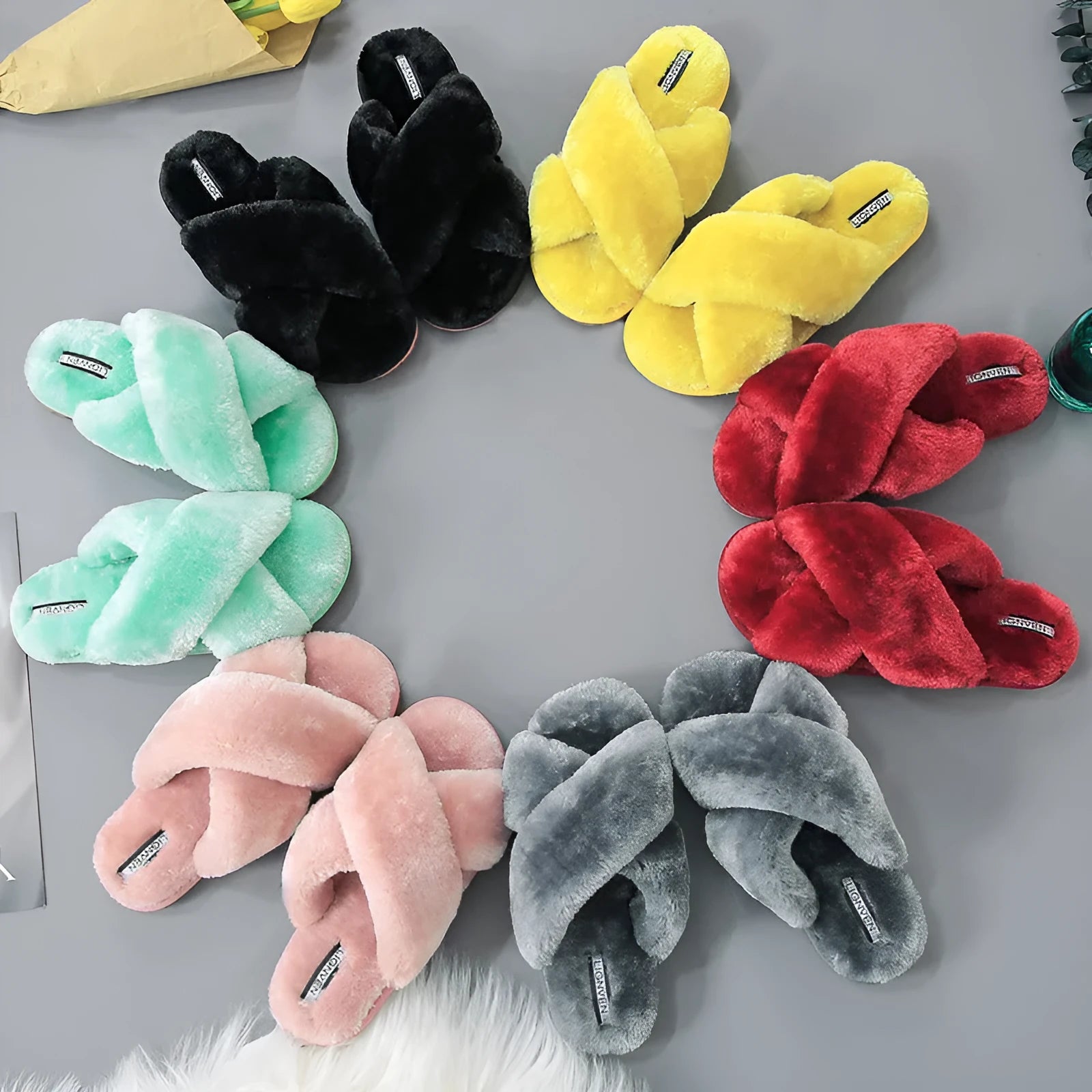Women's black open-toe fur slippers with a cross-strap design and textured non-slip rubber sole.