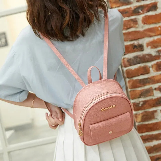 Black PU leather women's shoulder bag also worn as a small backpack, with zipper closure.