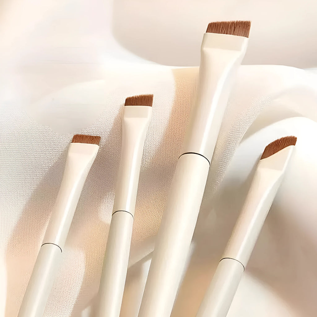 Four angled eyeliner and brow brushes with fine bristles in a leather makeup case