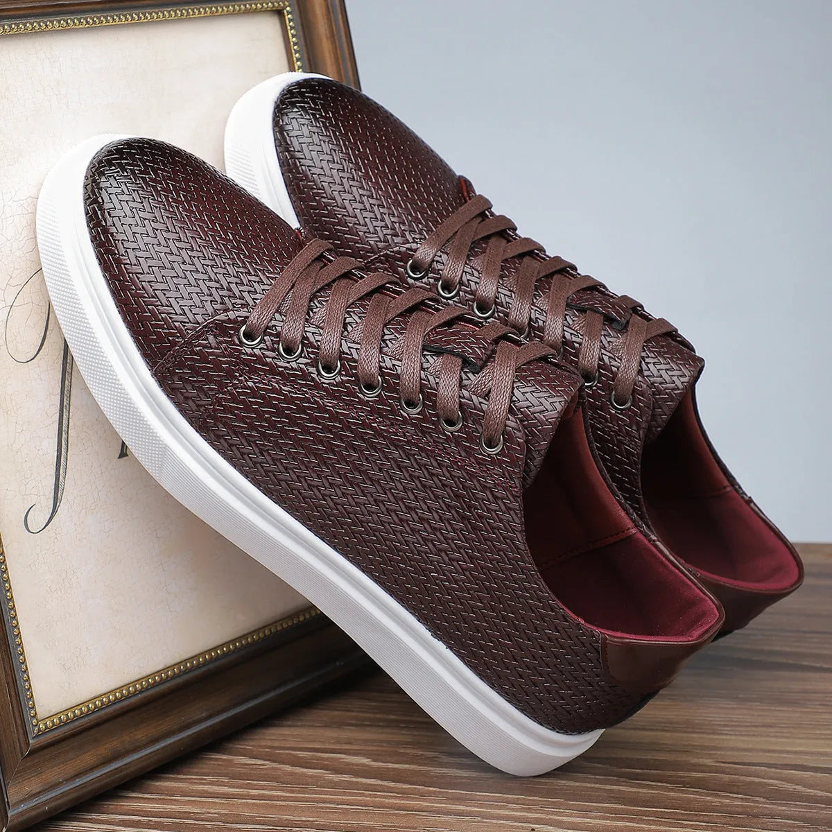 Men's low-top black leather-style shoes with decorative stitching and a rubber sole.