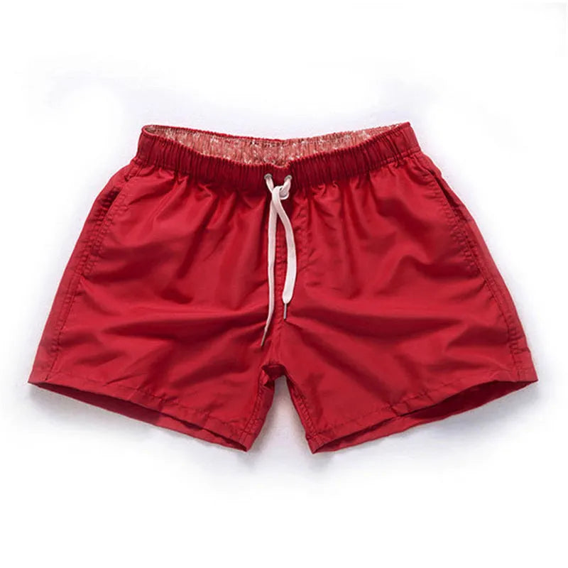 Men's straight-leg polyester beach shorts in black, shown on a model, highlighting the distressed finish and casual fit.