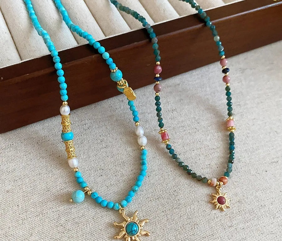 Freshwater pearl necklace with blue sun stone pendant on an adjustable clavicle chain.