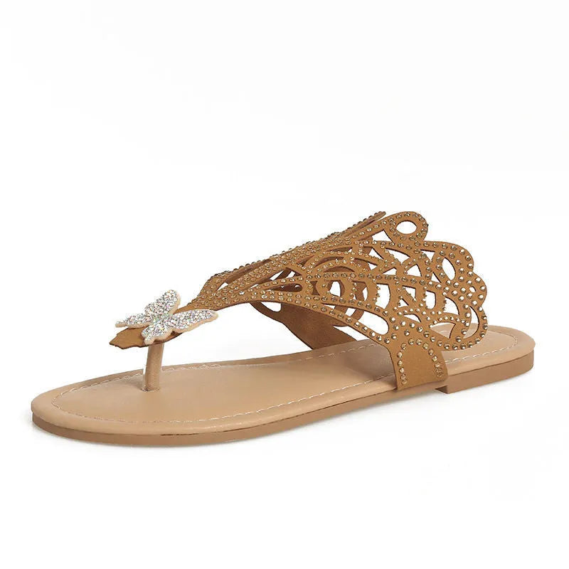 Women's black slip-on sandals with rhinestone detail across the toe and a flat rubber sole.