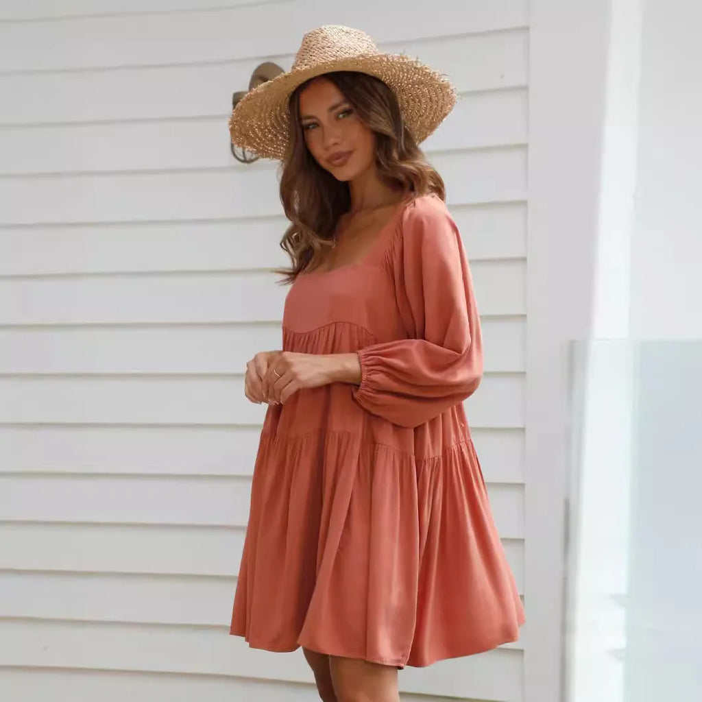 Orange children's backless dress with square collar and puff sleeves on hanger