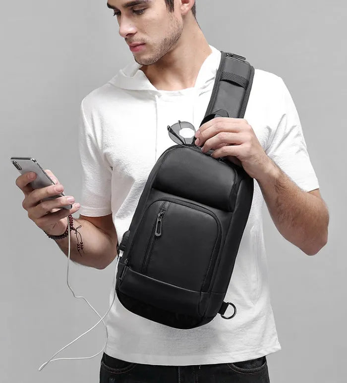 Black square vertical PVC shoulder bag showing organiser pockets and air cushion strap.