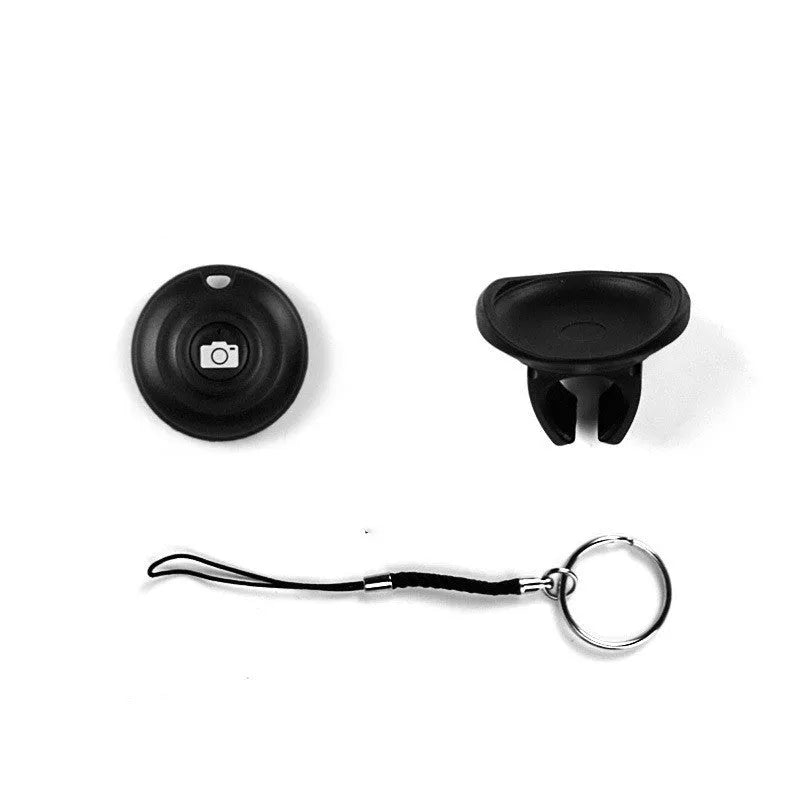 Black Bluetooth remote shutter for smartphones on a white background, shown next to a mobile phone.