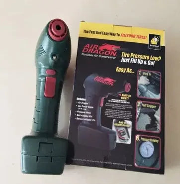 Portable electric car tyre inflator with motor and air pump components on a garage floor.
