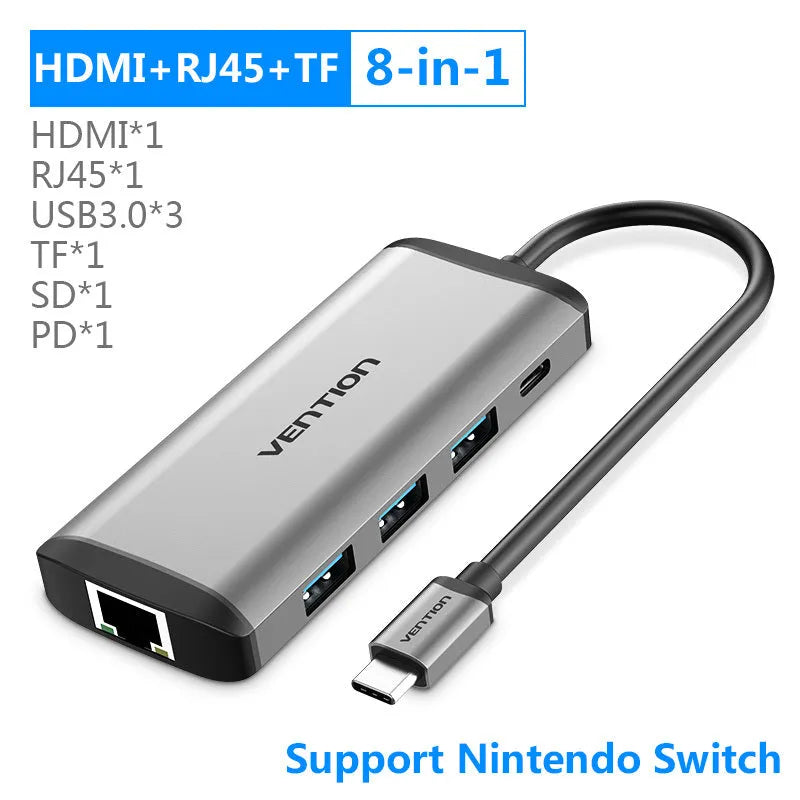 Deep grey CNDHB USB-C hub showing HDMI, Ethernet, USB ports, and card slots next to a laptop.
