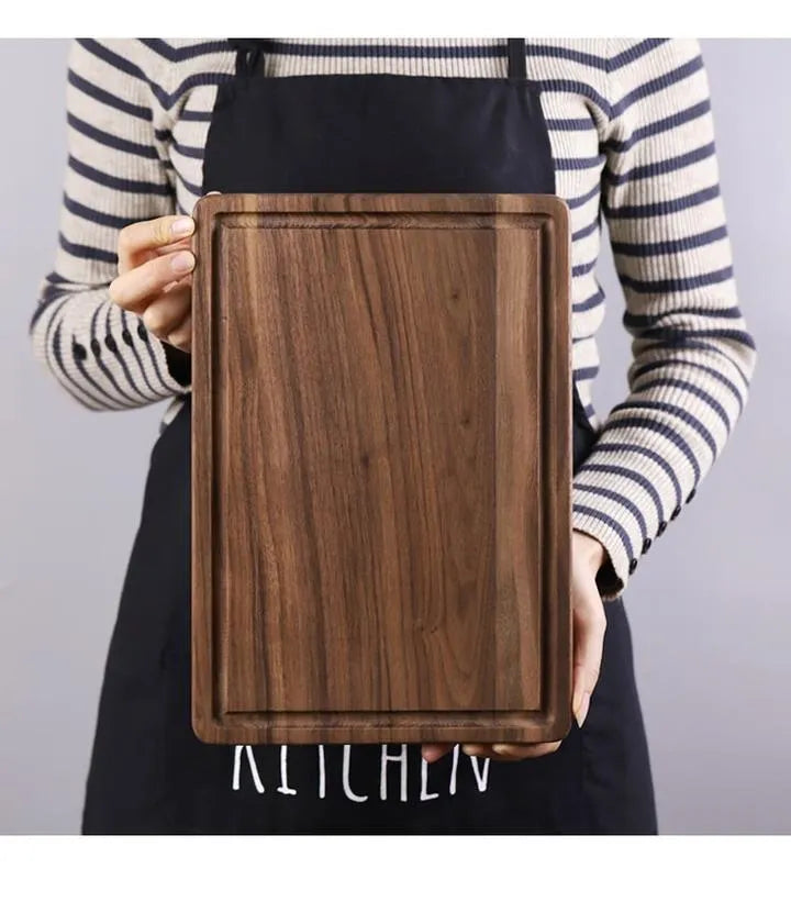 Solid black walnut wood chopping board with juice groove, available in round or rectangular sizes.