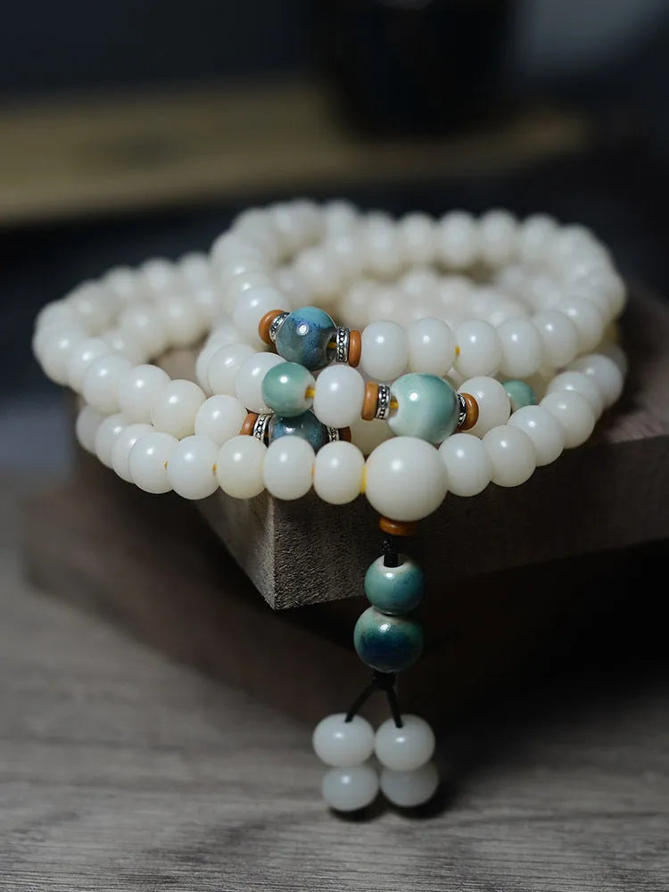 White jade bodhi root oblate bead bracelet with 108 flat round beads in 7x9mm and 8x10mm sizes.