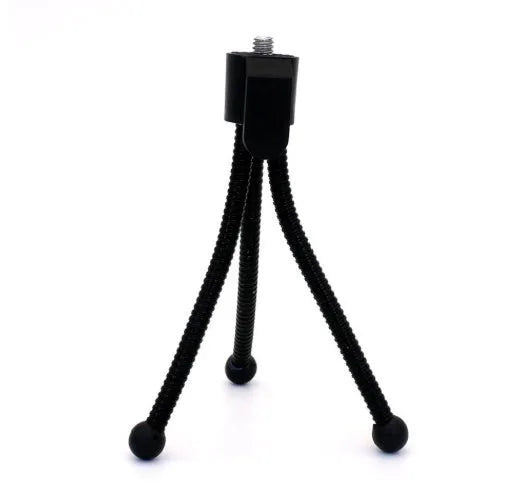 Compact black iron mini tripod with ball head, folded next to an iPhone for scale.