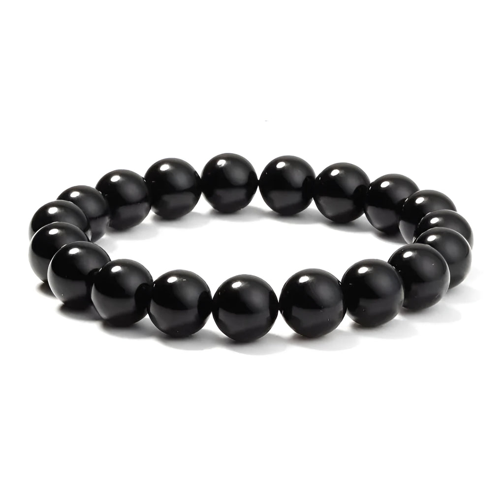 Close-up of a women's black agate bracelet with 8mm geometric beads on a black elastic cord.