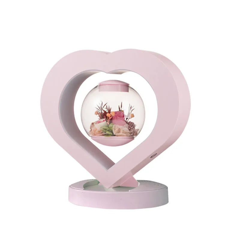 Pink preserved rose ornament with LED lights, shown with and without a decorative base.