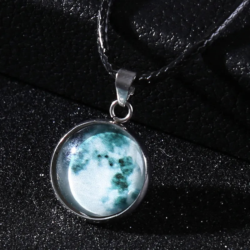 Luminous moon and star constellation pendant necklace with a silver-tone chain on a black background.
