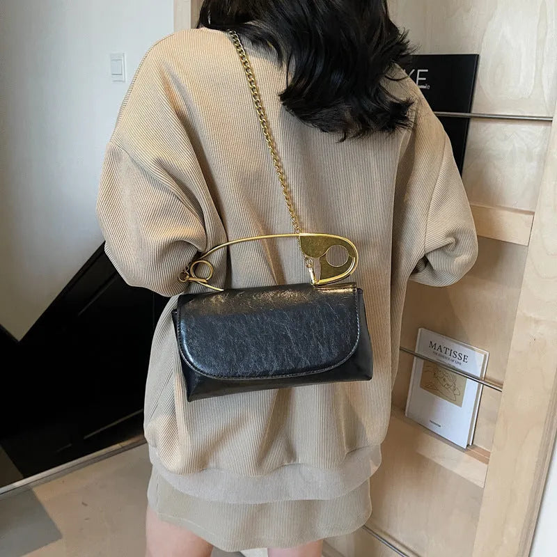 Creative personality paper clip shoulder handbag in PU leather with sandwich pocket and file bag interior.
