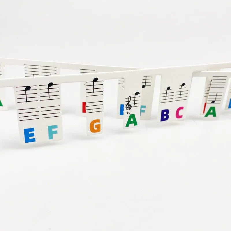 White cardboard piano note stickers for 88-key keyboards with black notes and colour bars in separate bags