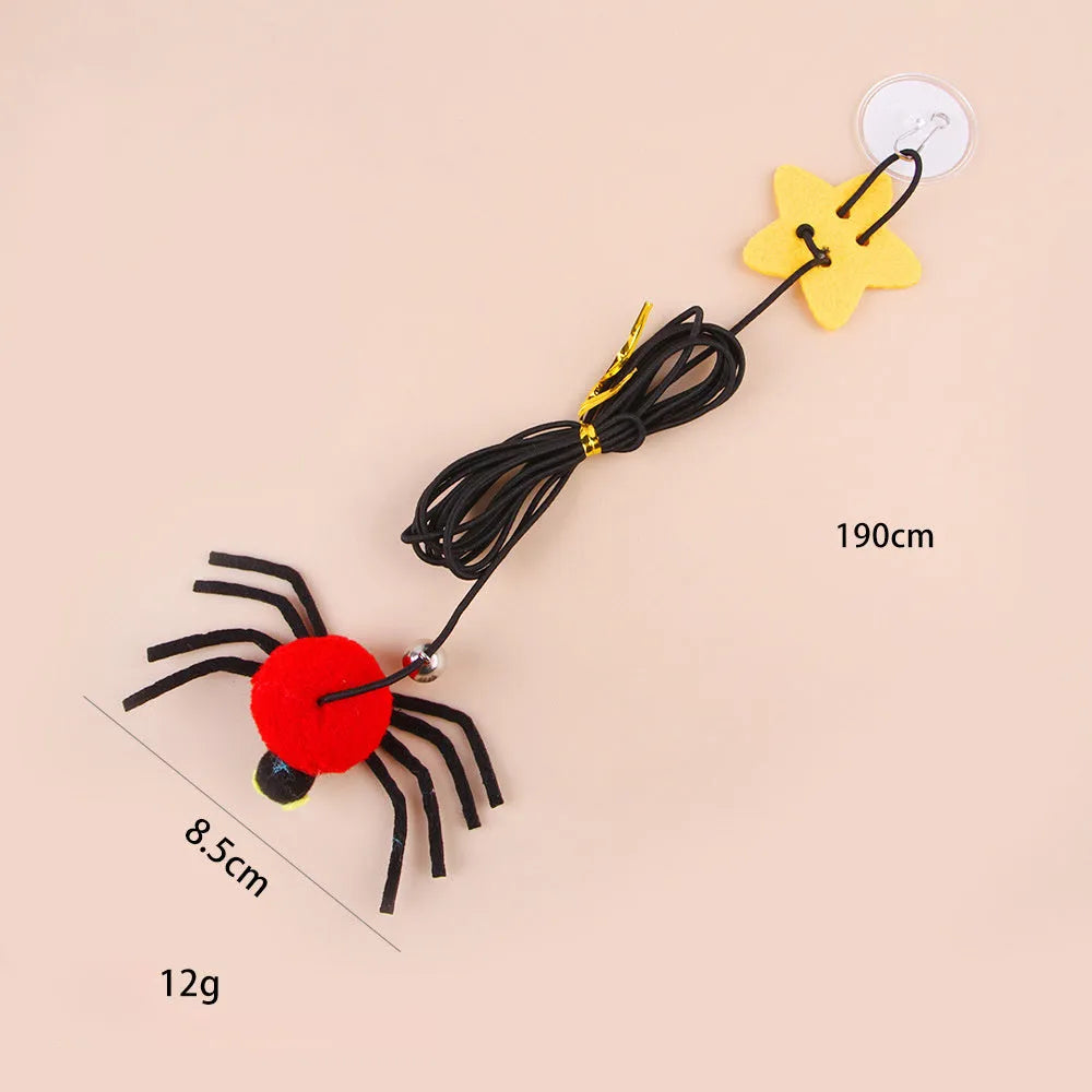 Cat toy with elastic rope hanging over a door, featuring a feather wand, jingle bell, and dangling spider attachment.