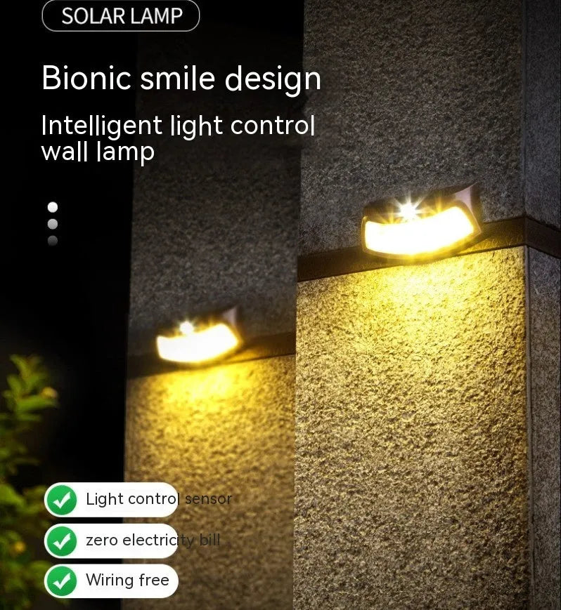 Solar-powered outdoor wall lamp with a smiling face design in a garden setting.