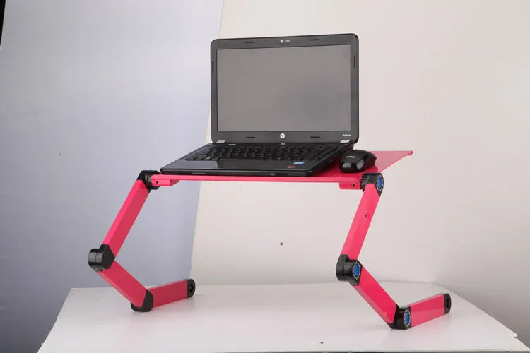 Black folding laptop table stand with six legs, magnesium alloy desktop, and attached mouse pad, folded view on a desk