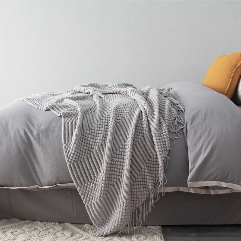 Small grey polyester nap blanket laid flat showing its size.
