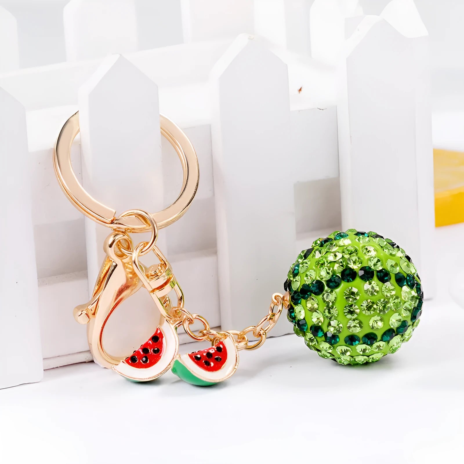 Green zinc alloy watermelon-shaped keychain on a white background.