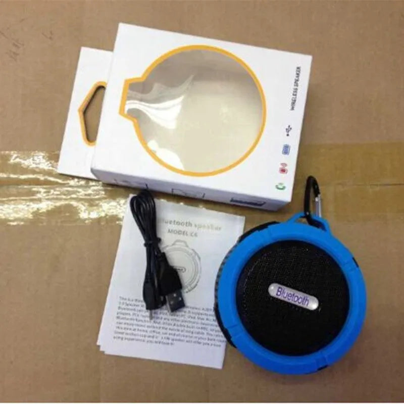 Compact waterproof Bluetooth speaker with a mounting strap in black, blue, green, red, or yellow.
