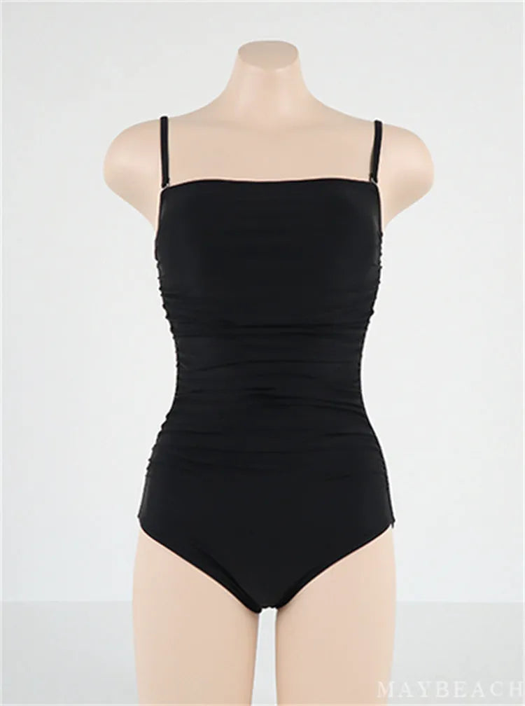 Women's sling style one-piece swimsuit with belly pleating in solid colour.