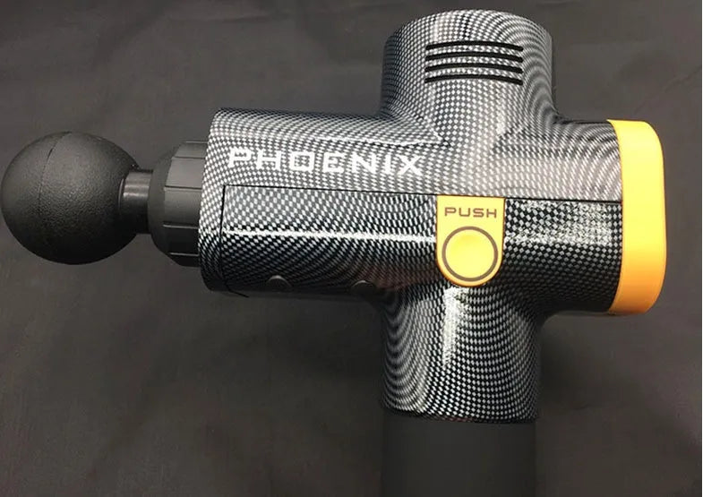 Black ABS fascia massage gun with four different coloured attachment heads on a grey surface.
