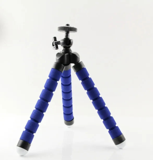 Black flexible octopus tripod with wrapped legs holding a smartphone next to a camera.
