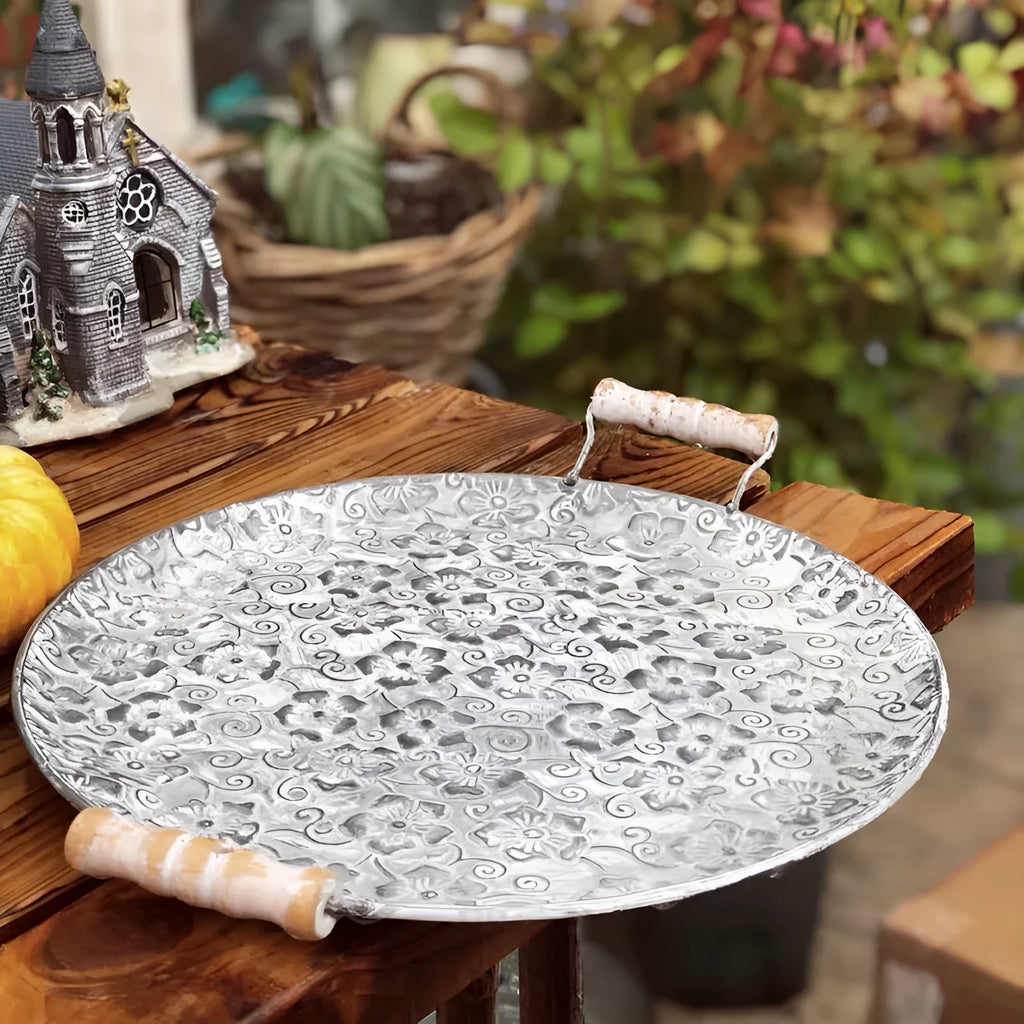Round wrought iron belt storage tray set in two sizes on a wooden table.