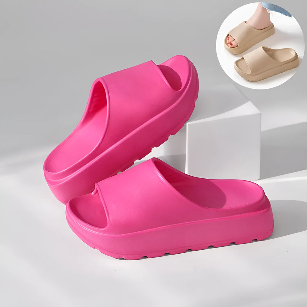 Women's beige thick-soled EVA beach slippers with fish mouth design on a wooden floor.