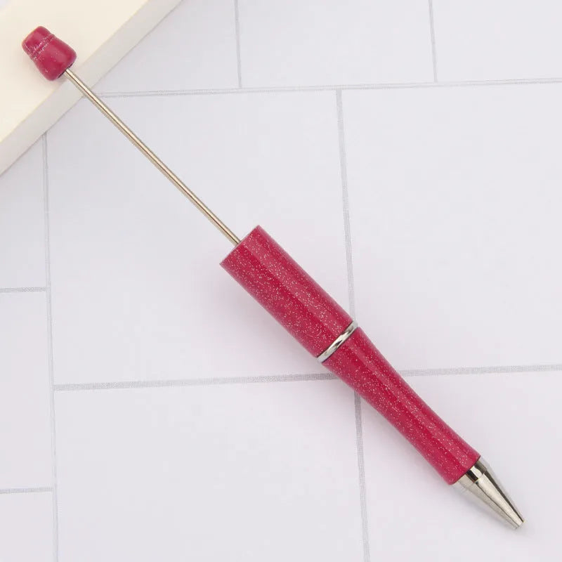 Colourful spinning ballpoint pen with plastic beads on a white background.