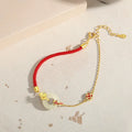 Gold koi peace buckle bracelet made from 925 silver with red rope closure