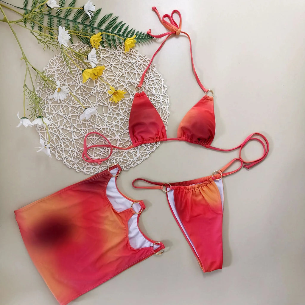 Tie-dye gradient three-piece swimsuit set with halter neck top, bikini bottoms, and matching skirt on a neutral background.