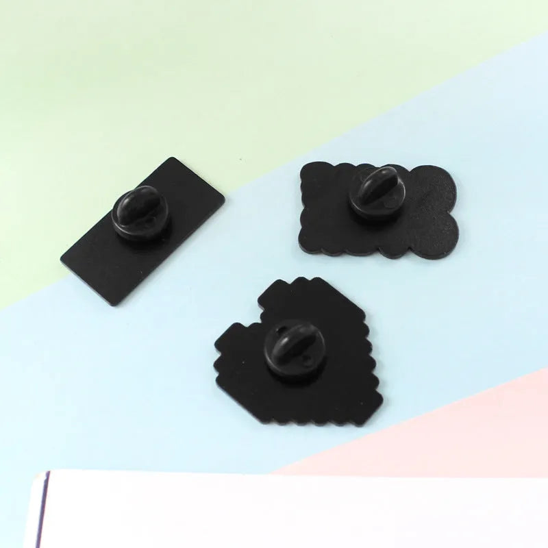 Stereo game console badge made of alloy metal in a three-dimensional design, shown in its OPP packaging.
