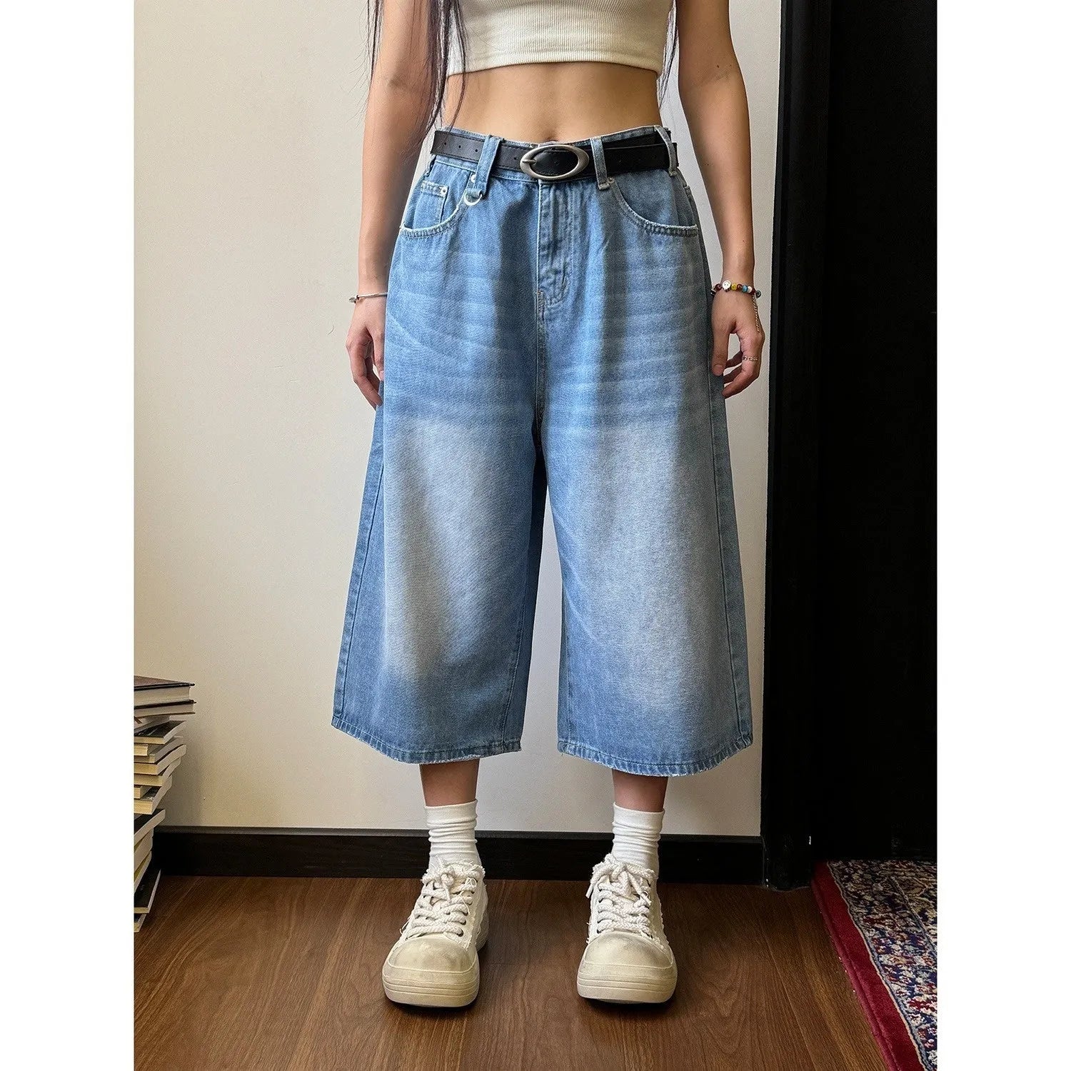 Men's straight-leg blue denim shorts with a loose fit and fifth pants length on a neutral background.