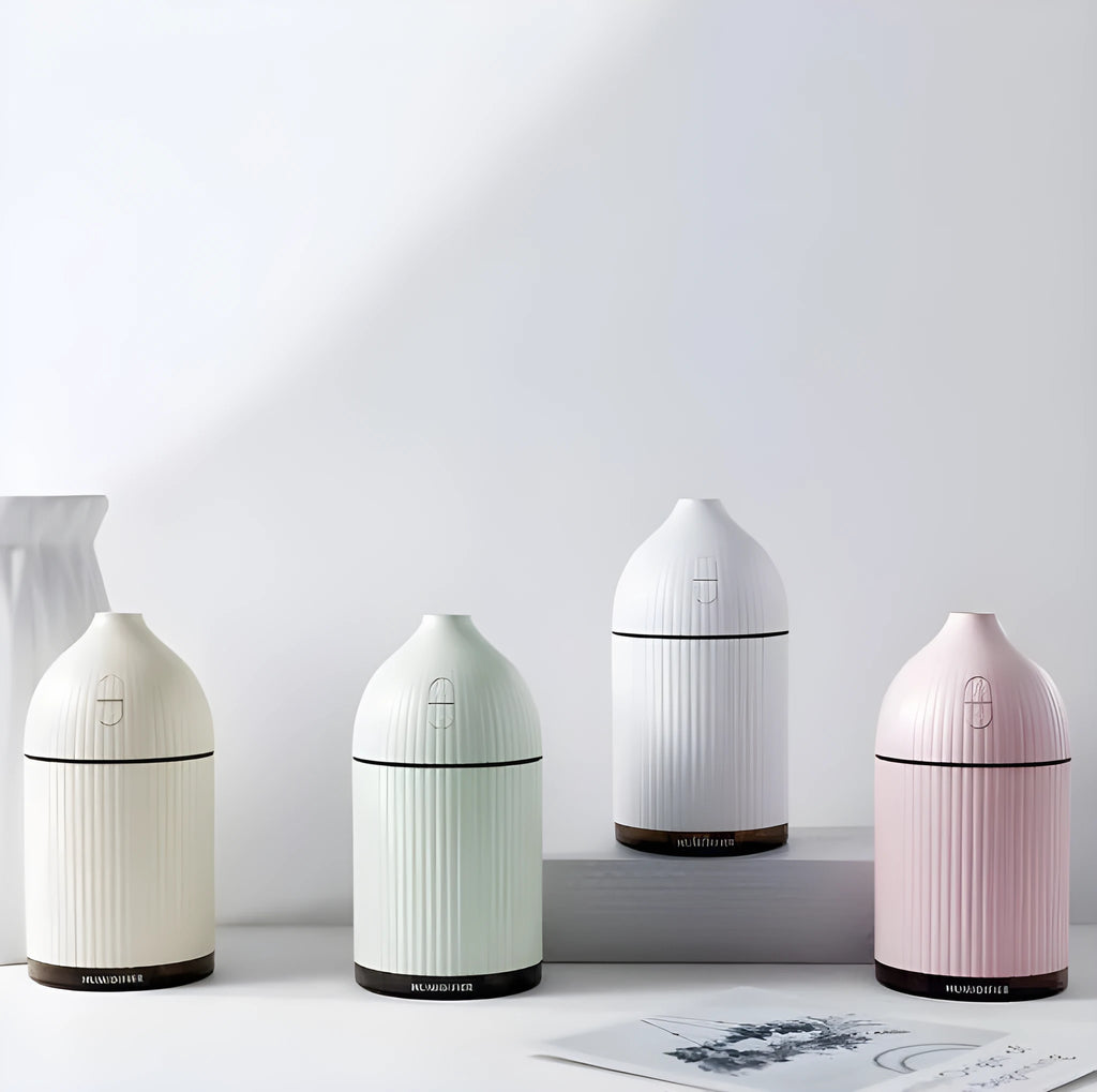 White USB aromatherapy diffuser and humidifier with LED light on a wooden desk