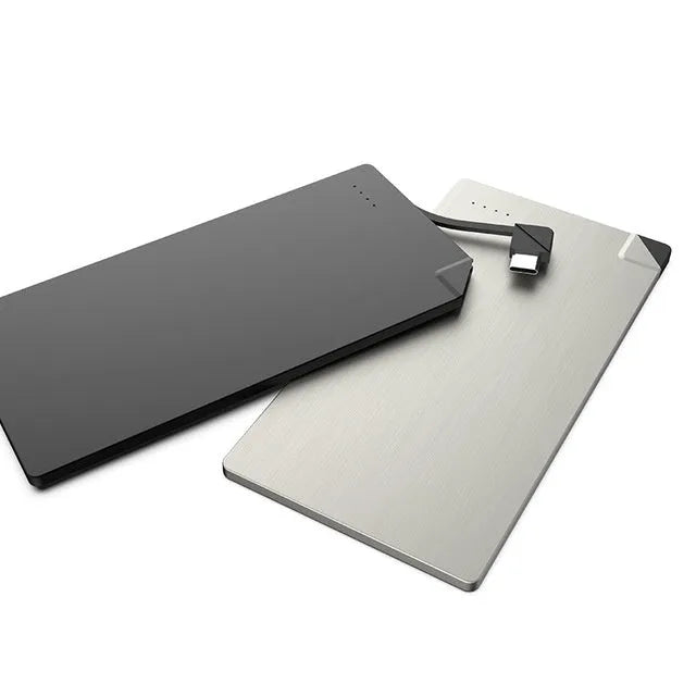 Silver ultra-thin 4mm graphene power bank next to a mobile phone showing its slim profile.
