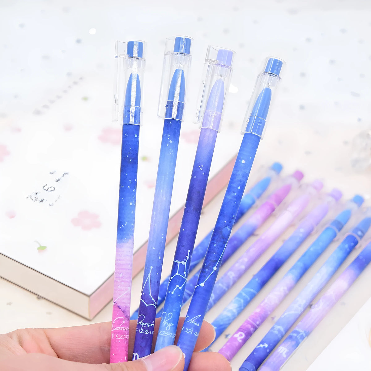 Box of 12 constellation-themed quick-drying gel pens with plastic bodies and coloured caps