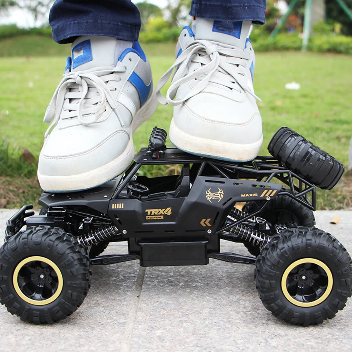Large black 4WD off-road remote control car with 2.4G wireless controller on rough terrain