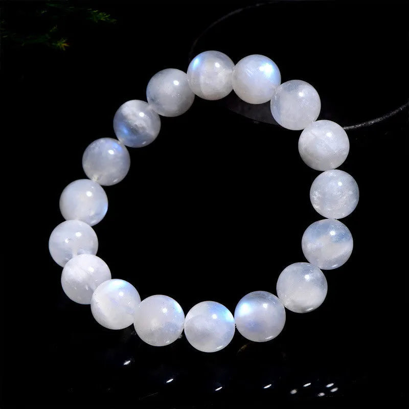 Natural blue moonlight round moonstone bead bracelet on a wrist, showing adjustable closure.