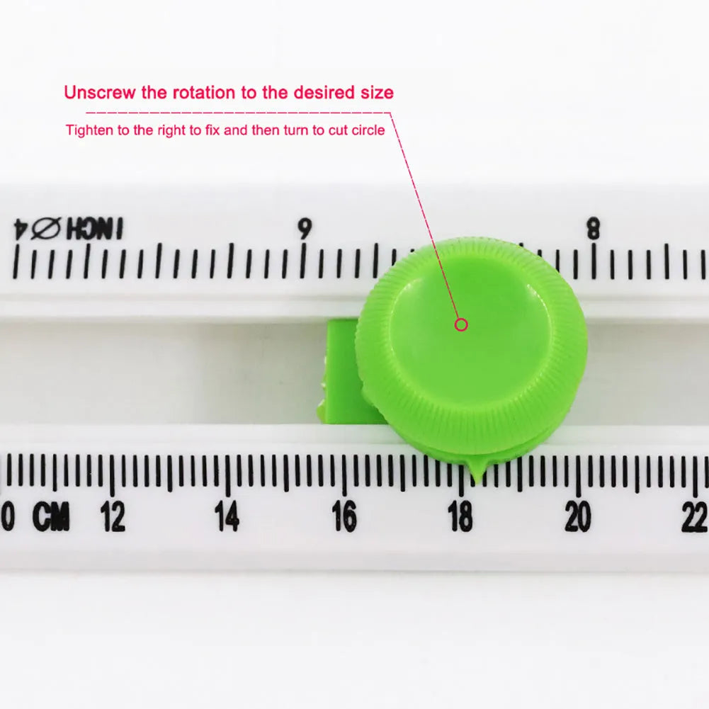 Green and orange plastic round paper cutter for cutting A3 sheets on a desk.