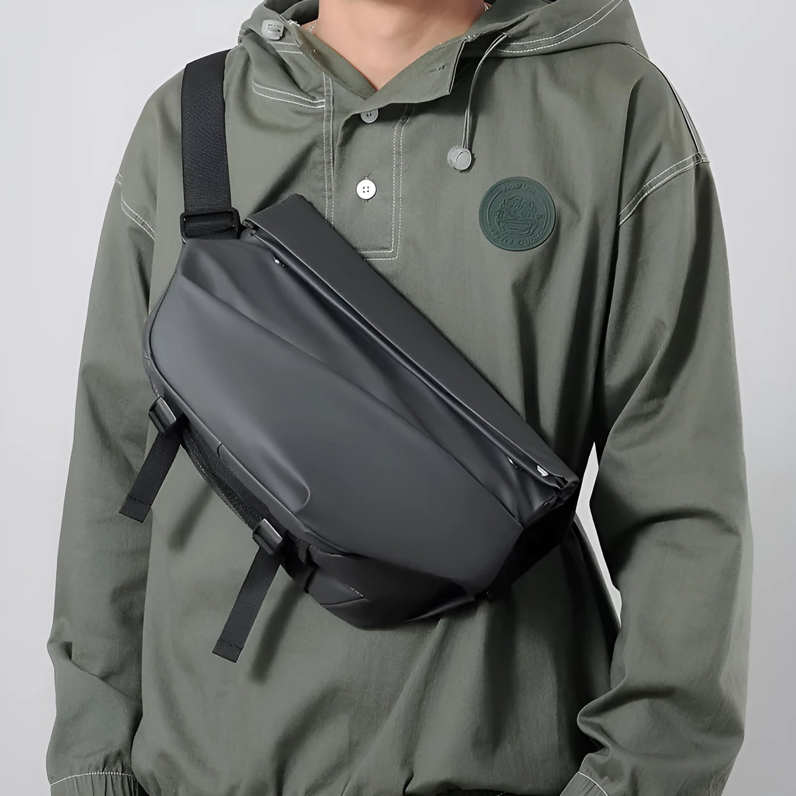 Grey crossbody bag for men showing horizontal square shape, shoulder strap, and zipper opening