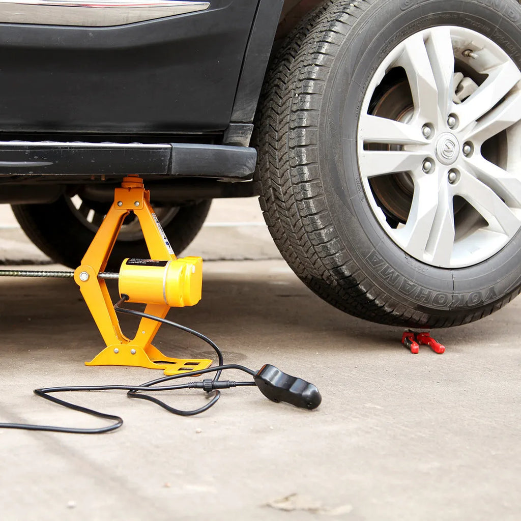 Hydraulic electric car jack kit with control box, shown stored in a vehicle boot.