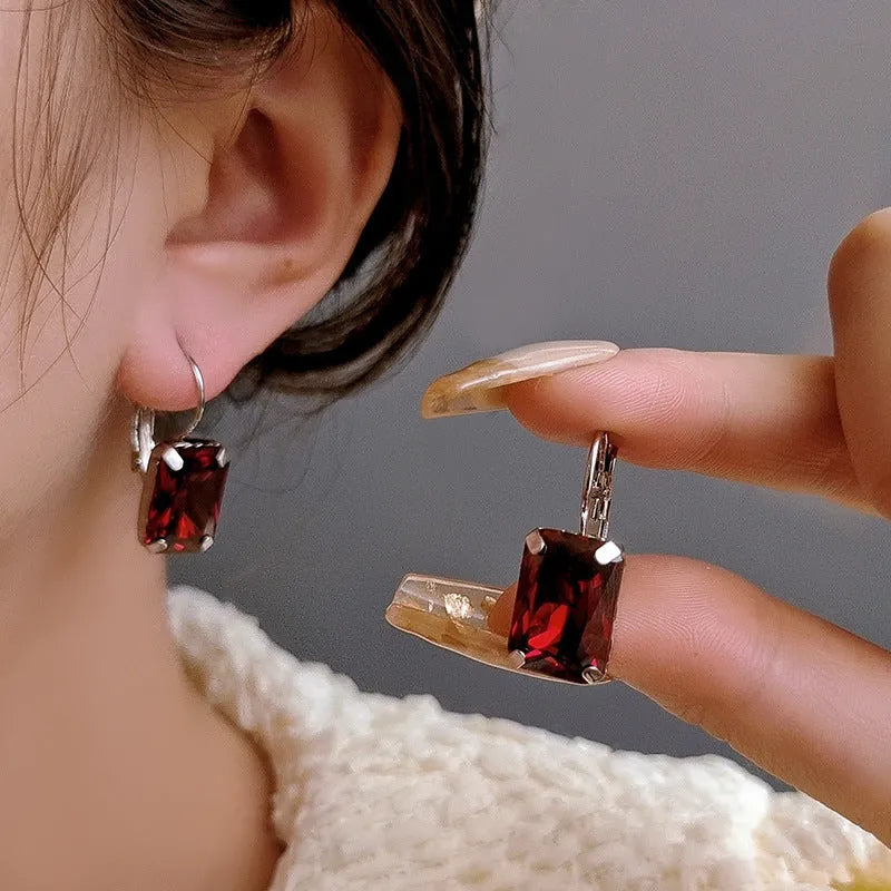 Square-shaped copper earrings with crystal decoration in red, yellow, or purple colours.