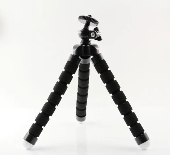 Black flexible octopus tripod with wrapped legs holding a smartphone next to a camera.