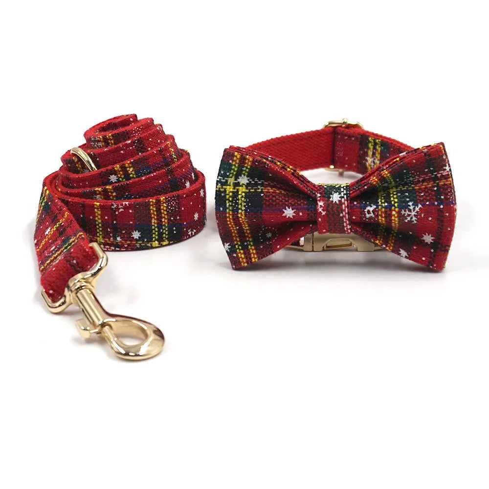 Red Christmas pet collar set with matching harness, leash, bow, and dog waste bag on cloth background