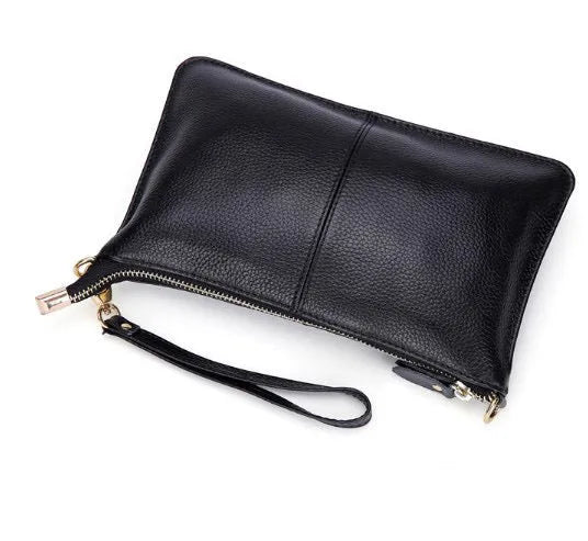 A small lady's cowhide slant handbag in claret colour, showing the hand strap and long shoulder strap.